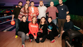 Agency members huddled together for holiday bowling fundraiser.