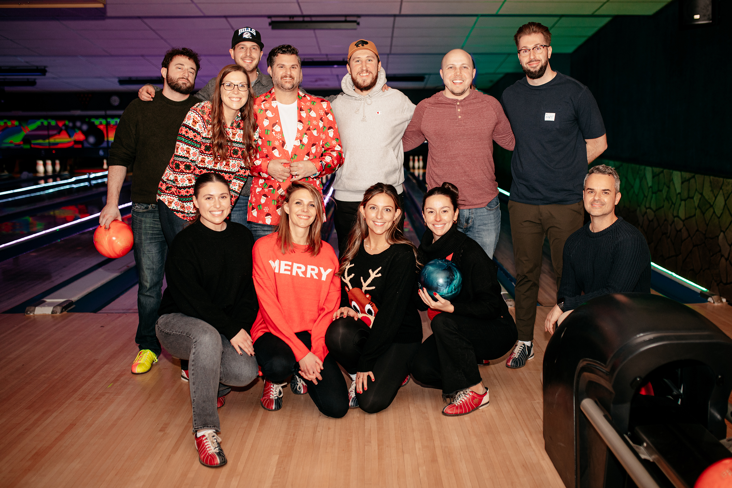 Agency members huddled together for holiday bowling fundraiser.