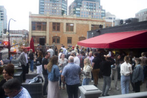 Crowd gathers on the rooftop of Soho as they raise money for scholarships